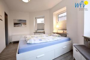 a bedroom with a large bed with blue sheets at Haus Solaris - Ferienwohnung D'runner un D'rover in Wangerooge