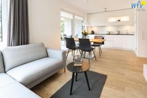 a living room with a couch and a table at Haus Talita - Wohnung ECHO in Juist