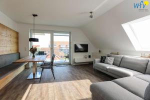 a living room with a couch and a table at Haus Talita - Wohnung ROMEO in Juist