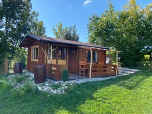 a small wooden cabin in a yard with trees at Cozy wood hut on the farm in Třebívlice