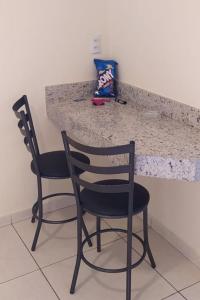 zwei Stühle an einer Theke in einer Küche in der Unterkunft Motel& Hotel Apê Goiânia !!! in Goiânia