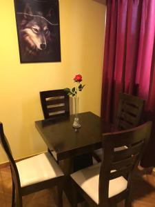 una mesa de comedor con una foto de lobo y un jarrón con una rosa en 300 Departamento Centrico distrito de chorrillos, en Lima