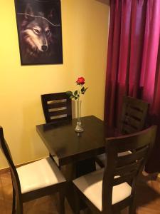 a dining room table with a wolf picture and a vase with a rose at 300 Departamento Centrico distrito de chorrillos in Lima +1 photo