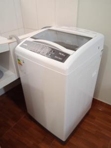 a white washing machine sitting on a wooden floor at 300 Departamento Centrico distrito de chorrillos in Lima