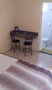 y baño con mesa, 2 sillas y aseo. en Motel& Hotel Apê Goiânia !!!, en Goiânia