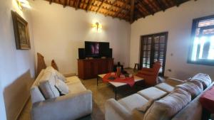 a living room with two couches and a tv at Pousada das Casuarinas in Paty do Alferes