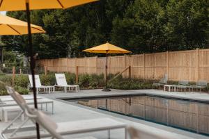 a patio with chairs and umbrellas and a pool at The Amelia in Hudson
