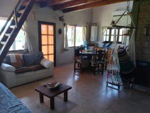 ein Wohnzimmer mit einem Sofa und einem Tisch in der Unterkunft Cabaña Los Reartes in Los Reartes