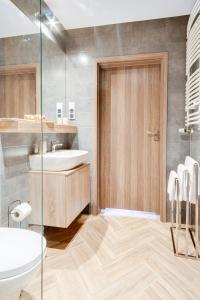 a bathroom with a sink and a toilet at Apartamenty Kozubnik - Apartament 16 z dużym tarasem in Porąbka