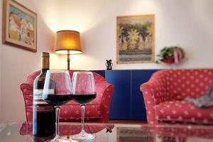 Diamante: Appartamento nel cuore della Toscana في Castelfranco di Sotto: زجاجة من النبيذ وكأسين على الطاولة