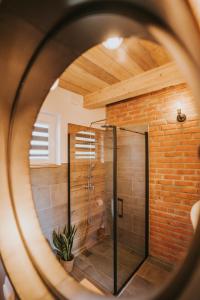 a shower in a room with a brick wall at Nowe Domki Jeleni Szlak in Ustrzyki Dolne +38 photos