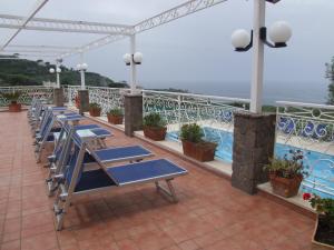 a row of blue lounge chairs on a balcony at Hotel Dania in Sorrento