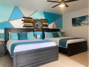 a bedroom with two beds and a ceiling fan at Aqua Marina Beach Club in Rincon +23 photos