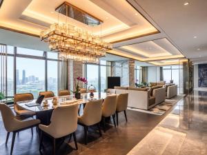 a dining room with a table and chairs and a chandelier at Sofitel Hangzhou Yingguan in Hangzhou