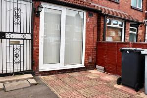 a front door of a brick house with a trash can at EXQUISITE FOLK VICTORIAN ONE-BED HOUSE: in Leeds