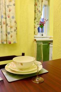 a bowl and a plate and a glass on a table at EXQUISITE FOLK VICTORIAN ONE-BED HOUSE: in Leeds