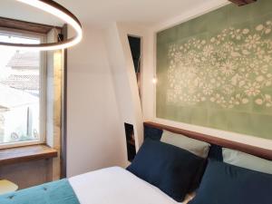 a bedroom with a bed and a wall with flowers at Gîte d'Architecte 6 Pers. avec Terrasse et Jardin à Pissotte - FR-1-426-480 in Pissotte