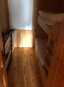 a small room with two bunk beds and a wooden floor at Charming Mountain Cabin in Oppdal