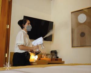 une femme dans un masque tenant un contrôleur de jeux vidéo dans l'établissement Cantera 1910 Hotel Boutique, Destination Hotel, à San Miguel de Allende