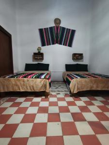 um quarto com duas camas e um piso xadrez em Cuarto Panchito ***Centro Histórico*** em Querétaro