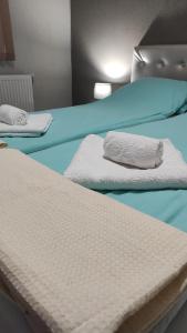 two beds with white sheets and towels on them at BeLApartment in Petrich
