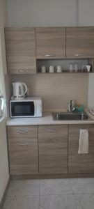 a kitchen with a microwave and a sink at BeLApartment in Petrich