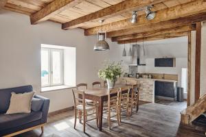 een keuken en eetkamer met een houten tafel en stoelen bij Le Pas De Moineau in Lhuis