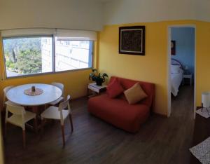 sala de estar con sofá rojo y mesa en Edificio Torre Antares Apt. 704, en Punta del Este