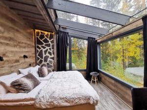 a bedroom with a bed and a large window at Glass Igloos by the water - Lasisviitit in Laukaa