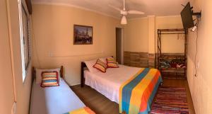 a bedroom with two beds and a window and a fan at Hotel Pousada Ibituruna inn in São Paulo