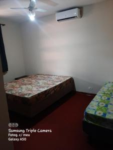 niewielka sypialnia z 2 łóżkami i wentylatorem w obiekcie Chacara Samambaia w mieście Piracicaba