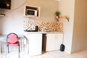 a kitchen with a counter and a red chair at Dumelang Executive Lodge- OFF-GRID Solar powered Midrand in Midrand