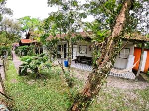 a house with a hammock in front of it at Pousada Recanto da Gruta in Ilha do Mel