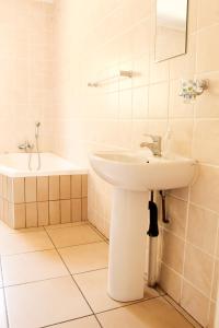 a white bathroom with a sink and a bath tub at Dumelang Executive Lodge- OFF-GRID Solar powered Midrand in Midrand