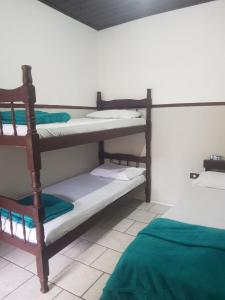 a room with two bunk beds and a bed at Pousada Recanto da Gruta in Ilha do Mel