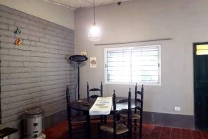 a dining room with a table and chairs and a window at Casa en El Manzano Histórico, Valle de Uco in Tunuyán