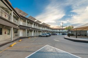 a parking lot with a car parked in front of a building at Hotel Sntenario in Chihuahua