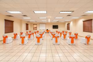 an empty room with orange chairs in a classroom at Hotel Sntenario in Chihuahua