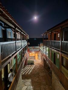una persona che cammina sul balcone di un edificio di notte di Pousada Cachoeiras de Milho Verde a Milho Verde