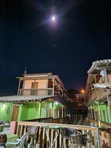 un grupo de edificios de noche con la luna en Pousada Cachoeiras de Milho Verde, en Milho Verde