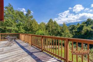 a deck with a bench and a view of the mountains at Honeymoon Cabin with Great Mountain View and Hot Tub in Gatlinburg