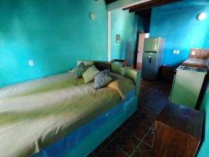 a large bed in a room with blue walls at CASA NANTLI in Yelapa