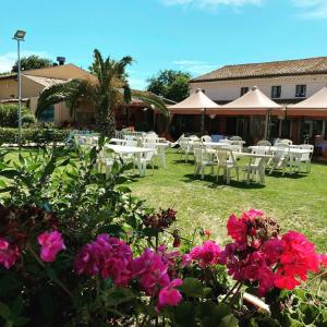 a group of tables and chairs in a yard with flowers at Locanda del Tavolo Matto in Potenza Picena