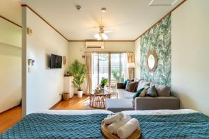una camera da letto con due letti e un soggiorno di Type D Room 35平米 -ウル エスポワール石垣- a Isola di Ishigaki