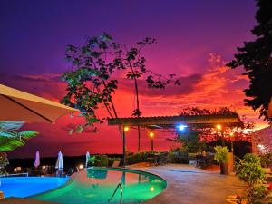 una piscina con una puesta de sol en el fondo en Vista Ballena, en Uvita