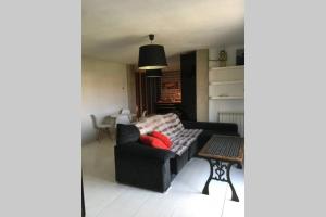 a living room with a black couch and a table at Loft de diseño con garaje in Santander