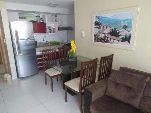 a kitchen and dining room with a table and a refrigerator at Apt 219 in João Pessoa