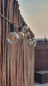 Une rangée de lumières suspendues à une clôture dans l'établissement Romántico apartamento, piscina y BBQ en Playa La Tejita, à El Médano