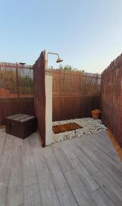 un patio trasero con una valla de madera y un banco en Romántico apartamento, piscina y BBQ en Playa La Tejita en El Médano