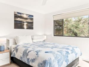 een witte slaapkamer met een bed en een raam bij The Grey Havens in Evans Head